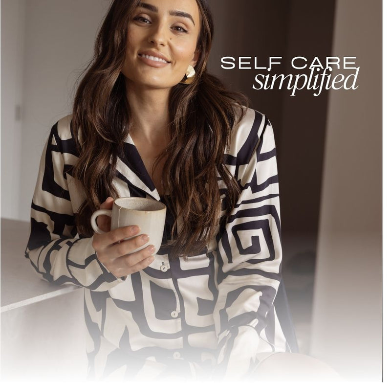 Woman smiling in silky pjs holding a cup of tea with the description "self care simplified"