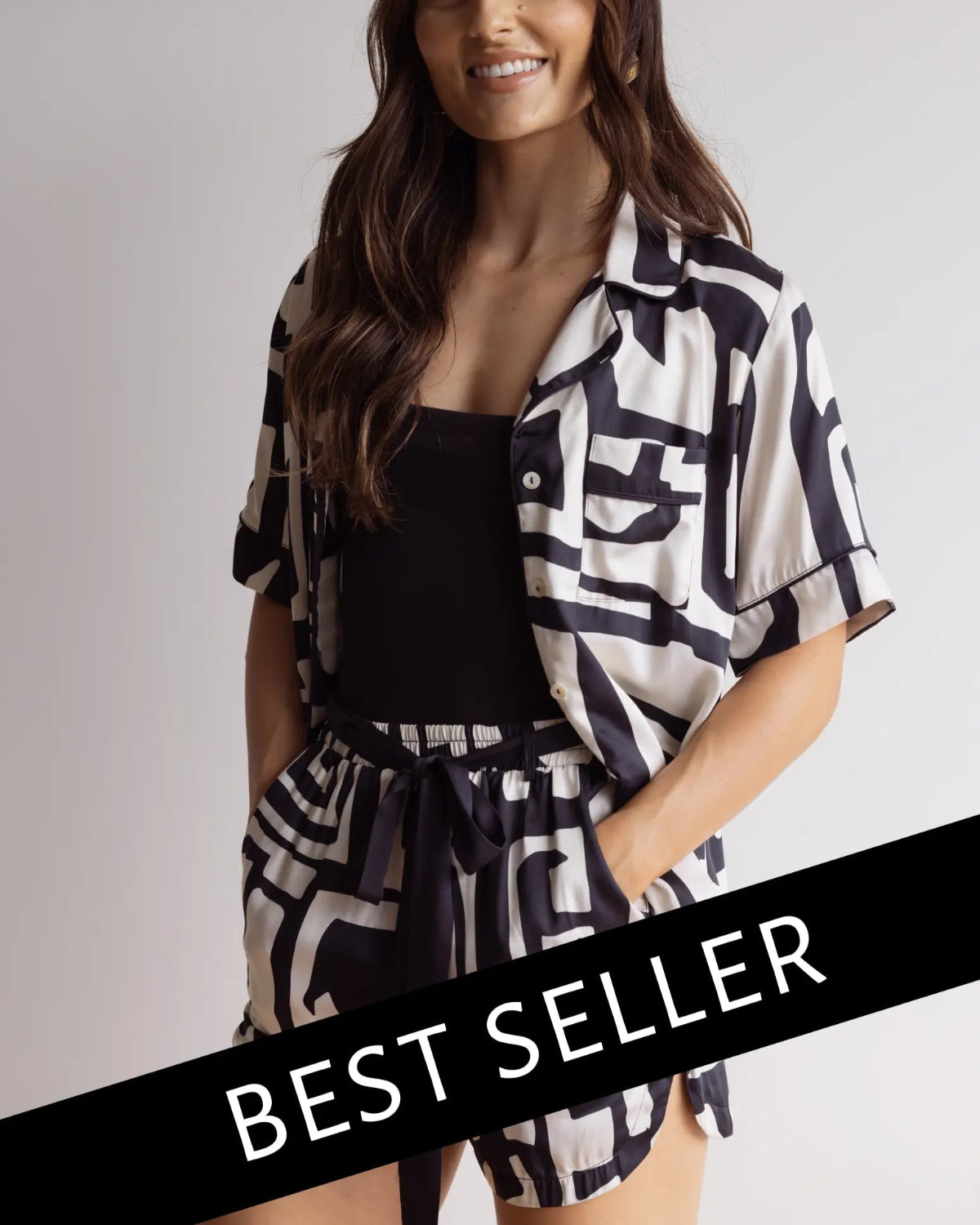 A female model wearing a short sleeve button-down bamboo top and matching shorts with a graphic pattern, in a standing pose with a 'BEST SELLER' text overlay.