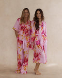 Two women in pink floral bamboo sleepwear. One in a kimono style robe, the other in a pyjama set with short sleeves and pants. These products are sold as a sleepwear bundle for extra savings.