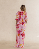 Back view of a woman wearing a bold pink floral bamboo pyjama set with short sleeves and long pants. with pockets – soft, breathable women’s sleepwear designed in Australia