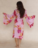 Woman in pink floral bamboo kimono style robe, with wide sleeves - elegant, breathable luxury sleepwear for women designed in Australia.