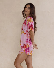 Woman wearing a pink floral bamboo pyjama set, view from the side, as she looks over her shoulder – soft, breathable luxury sleepwear for women designed in Australia