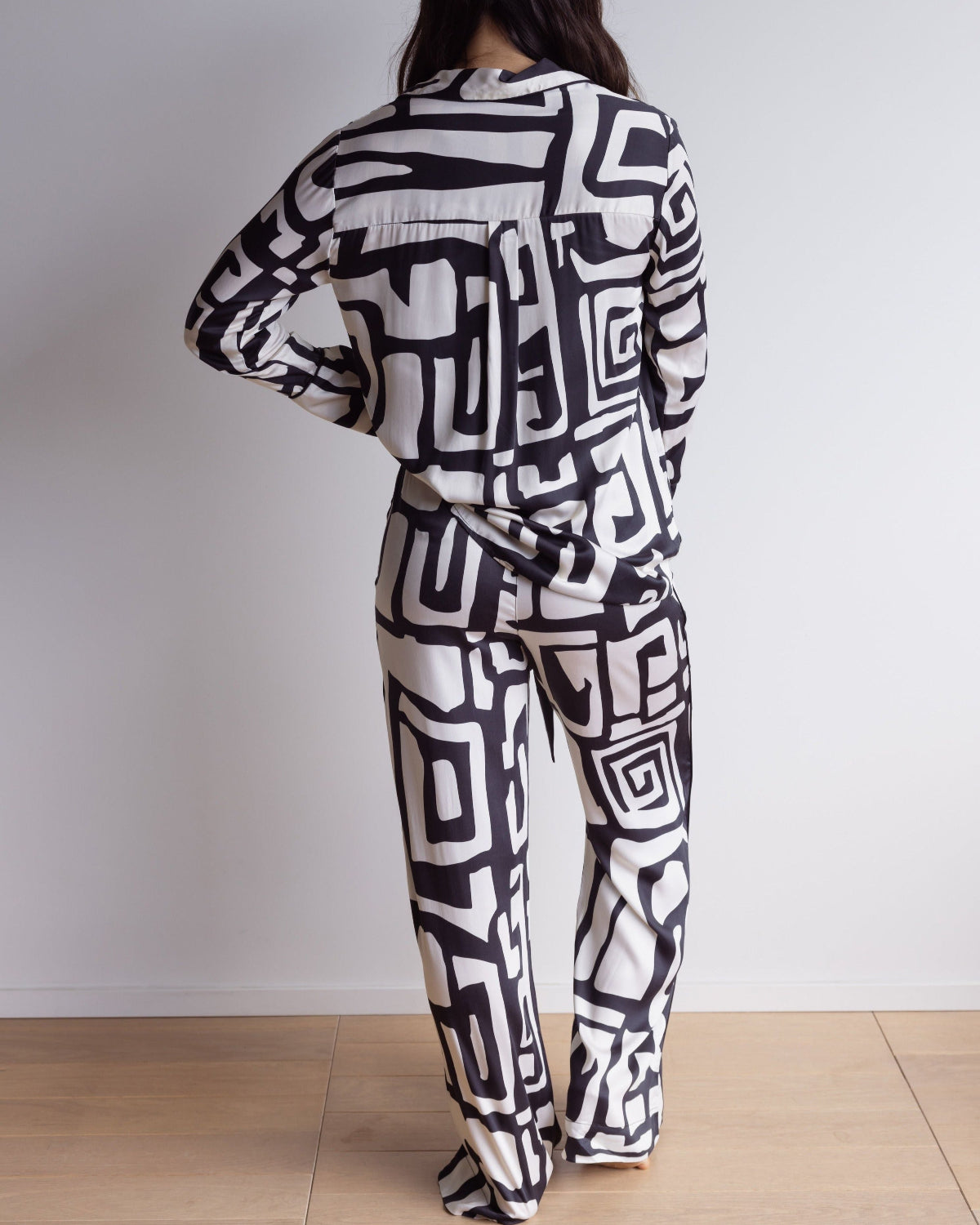 Back of a black and cream pj set with long sleeves and pants, made of silky soft bamboo satin