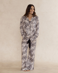 A woman wearing animal print bamboo pyjama set with long sleeves and long pants, with pockets – soft, breathable women’s sleepwear designed in Australia.