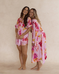 Two women wearing silky soft bamboo sleepwear in a pink floral print. One in kimono style robe, the other in a short pyjama set. Both items are sold as a sleepwear bundle for extra savings.