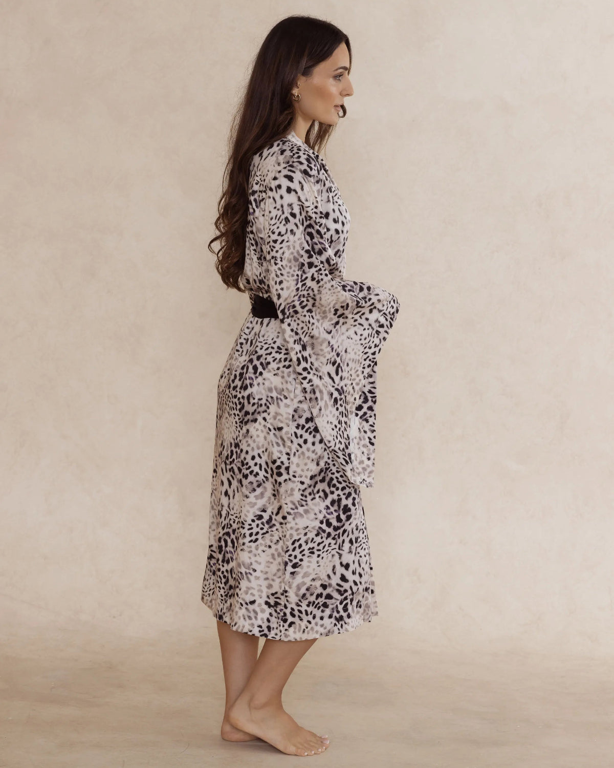 Woman wearing a animal print kimono style robe, with dramatic sleeves, an adjustable waist tie and pockets – bamboo robe, lightweight, breathable luxury women’s sleepwear designed in Australia.