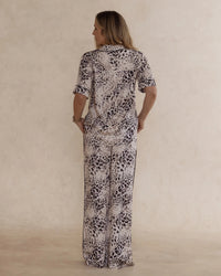 Back view of a woman wearing animal print bamboo pyjama set with short sleeves and long pants. with pockets – soft, breathable women’s sleepwear designed in Australia