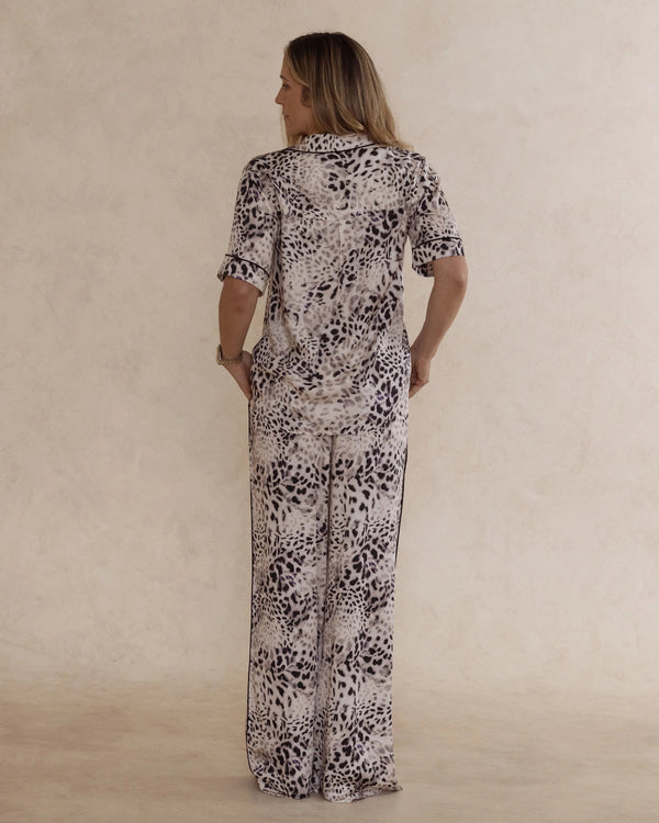 Back view of a woman wearing animal print bamboo pyjama set with short sleeves and long pants. with pockets – soft, breathable women’s sleepwear designed in Australia