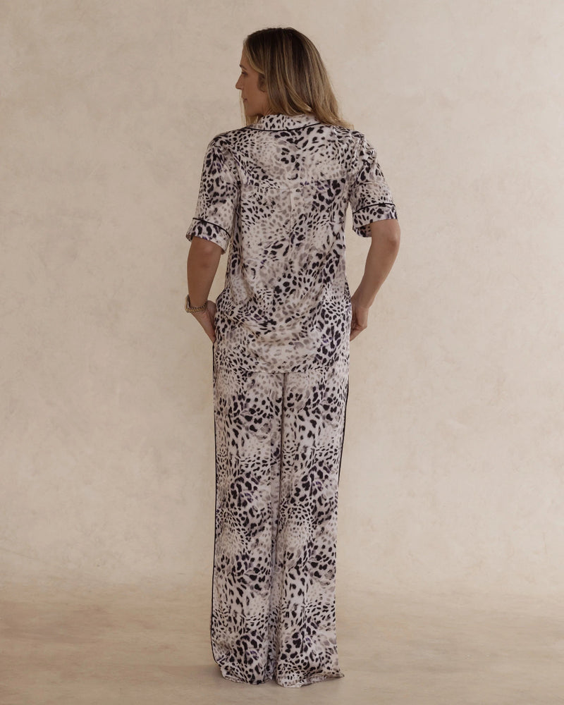 Back view of a woman wearing animal print bamboo pyjama set with short sleeves and long pants. with pockets – soft, breathable women’s sleepwear designed in Australia