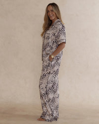 Woman wearing animal print bamboo pyjama set with short sleeves and long pants. with pockets – soft, breathable women’s sleepwear designed in Australia