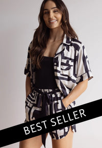 A female model wearing a short sleeve button-down bamboo top and matching shorts with a graphic pattern, in a standing pose with a 'BEST SELLER' text overlay.