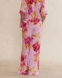 Woman wearing pink floral bamboo pants with pockets. Silky soft, elegant, breathable luxury sleepwear for women designed in Australia.
