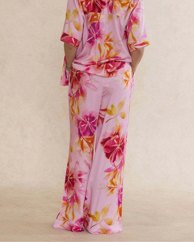 Woman wearing pink floral bamboo pants with pockets. Silky soft, elegant, breathable luxury sleepwear for women designed in Australia.