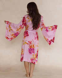 Woman in pink floral bamboo kimono style robe, with wide sleeves - elegant, breathable luxury sleepwear for women designed in Australia.