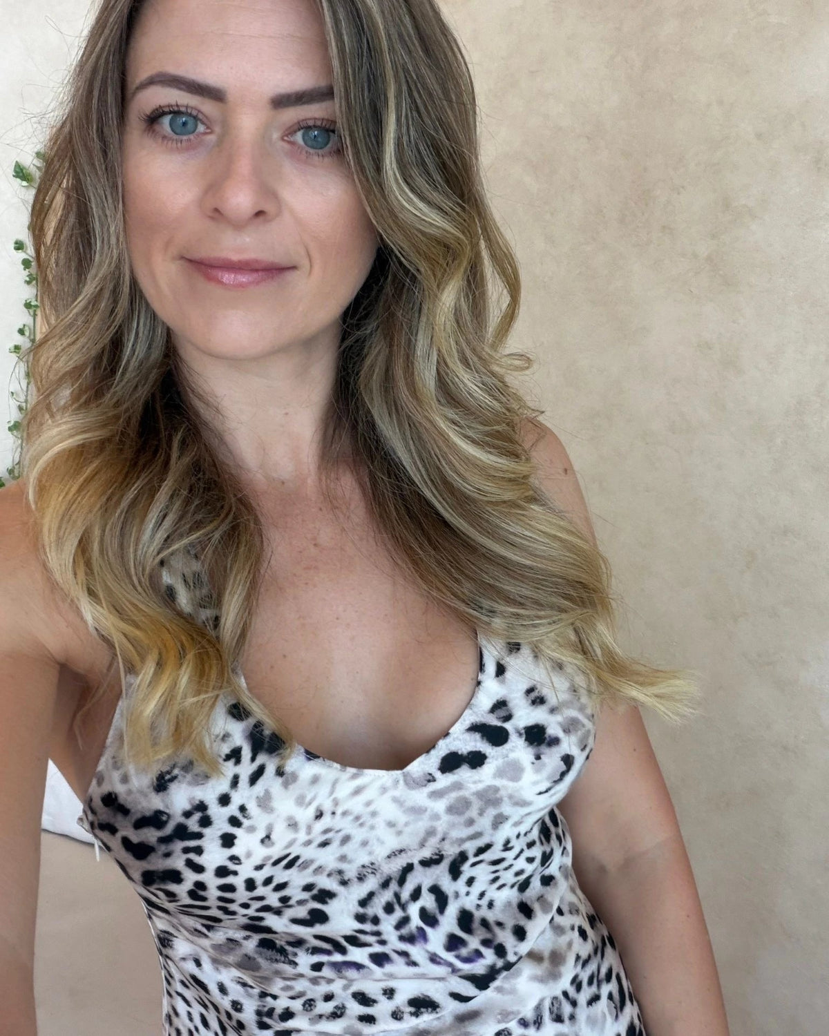 Selfie of a woman wearing a v-neck leopard print cami top made from bamboo satin.