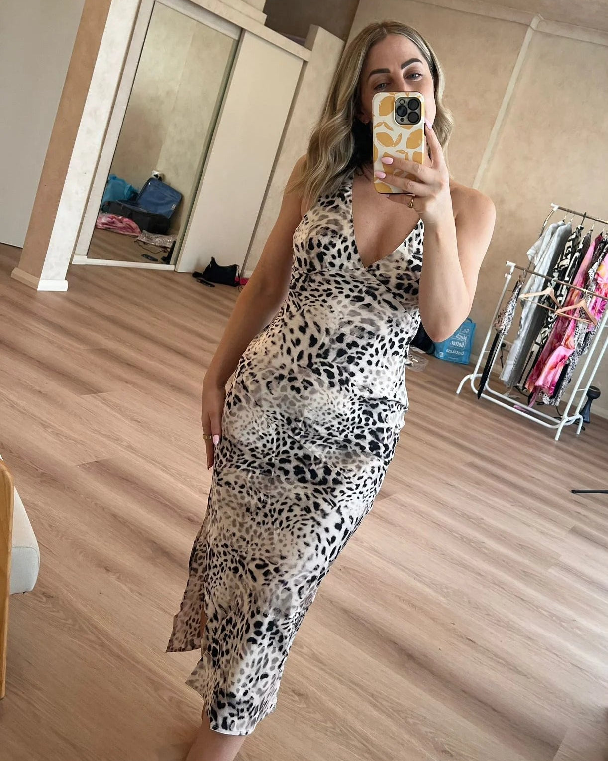 Woman taking a selfie wearing a leopard print slip dress with a V-line neck, spaghetti straps and figure hugging silky bamboo satin.