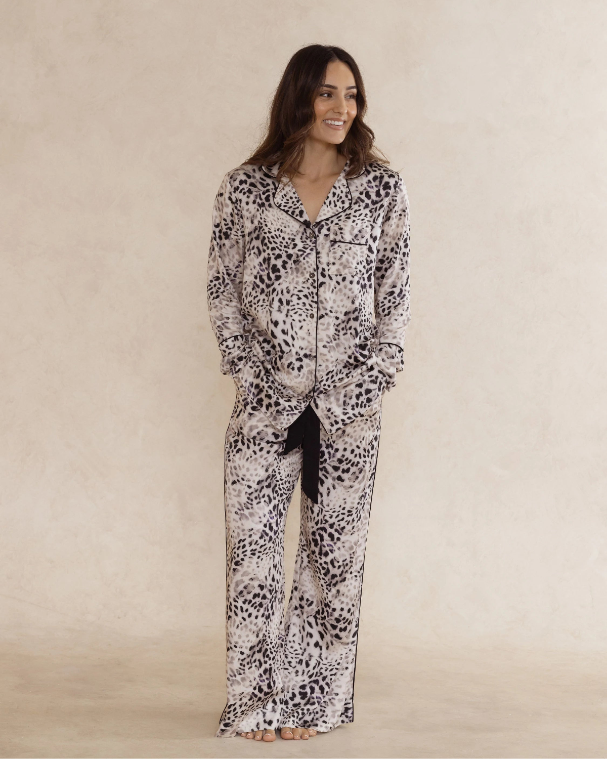 A woman wearing animal print bamboo pyjama set with long sleeves and long pants, with pockets – soft, breathable women’s sleepwear designed in Australia.