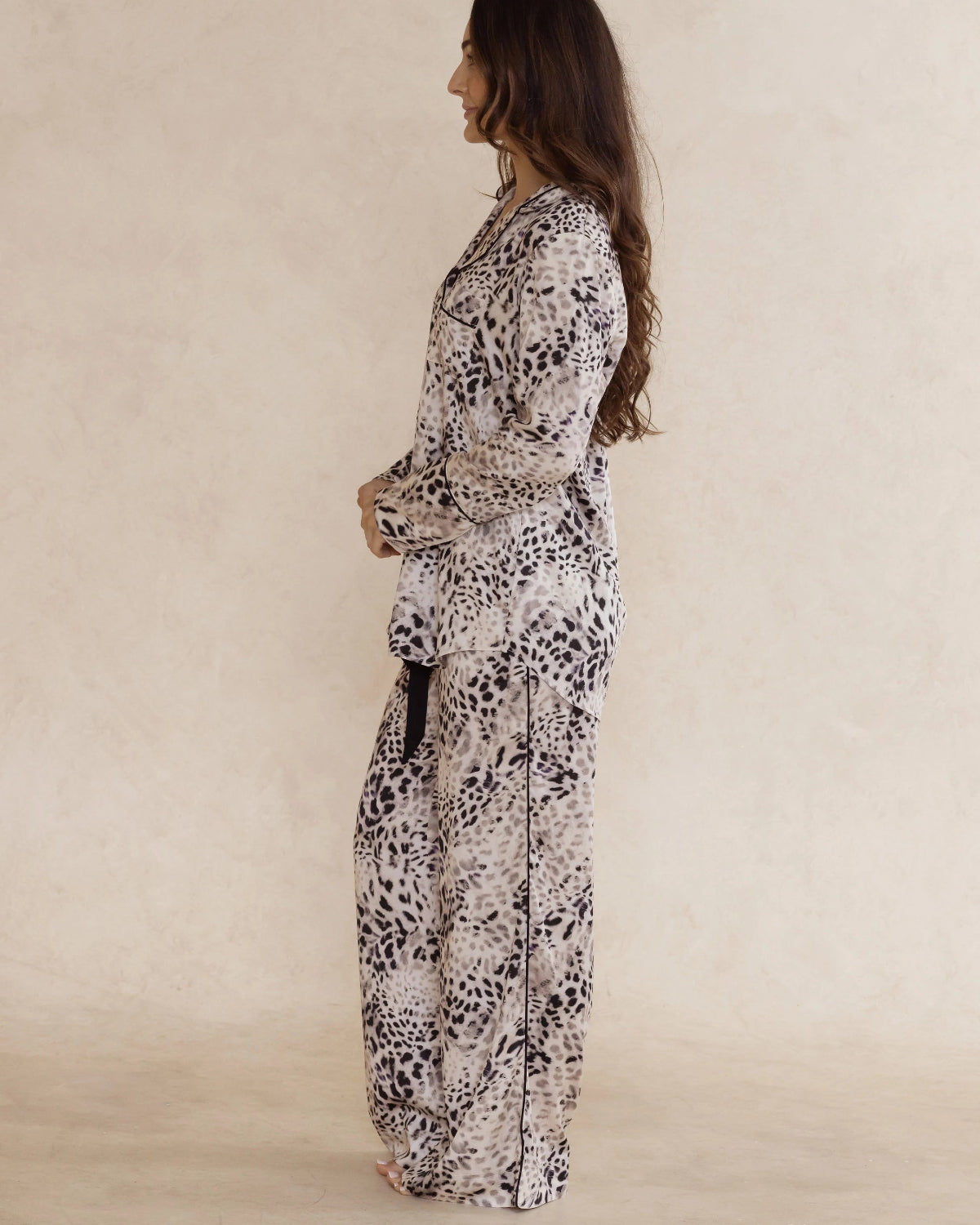 A woman wearing animal print bamboo pyjama set with long sleeves and long pants, with pockets – soft, breathable women’s sleepwear designed in Australia.
