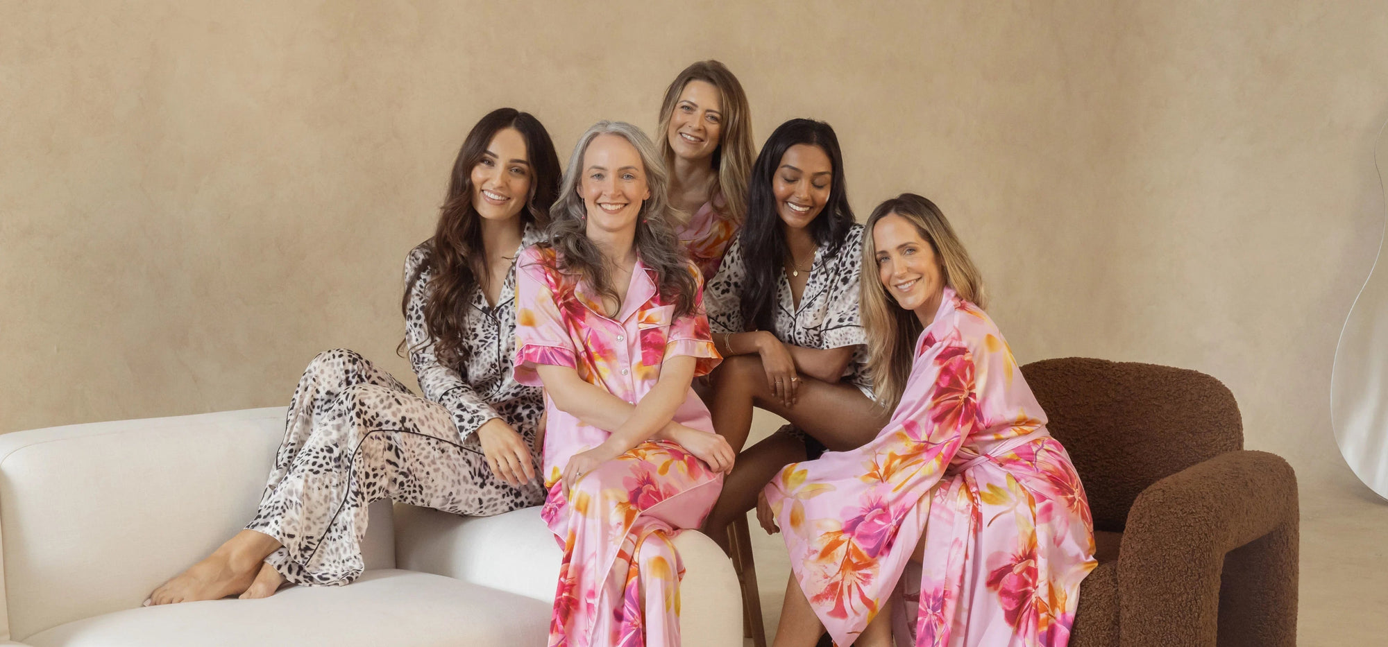 Five women wearing pyjamas a robes made from silky soft, breathable bamboo in pink floral and animal print. Sleepwear designed in Australia