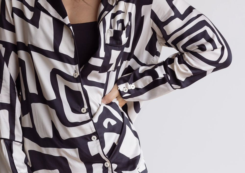 Woman wearing silky-soft black and cream silky soft satin bamboo pyjamas – breathable long sleeve top.