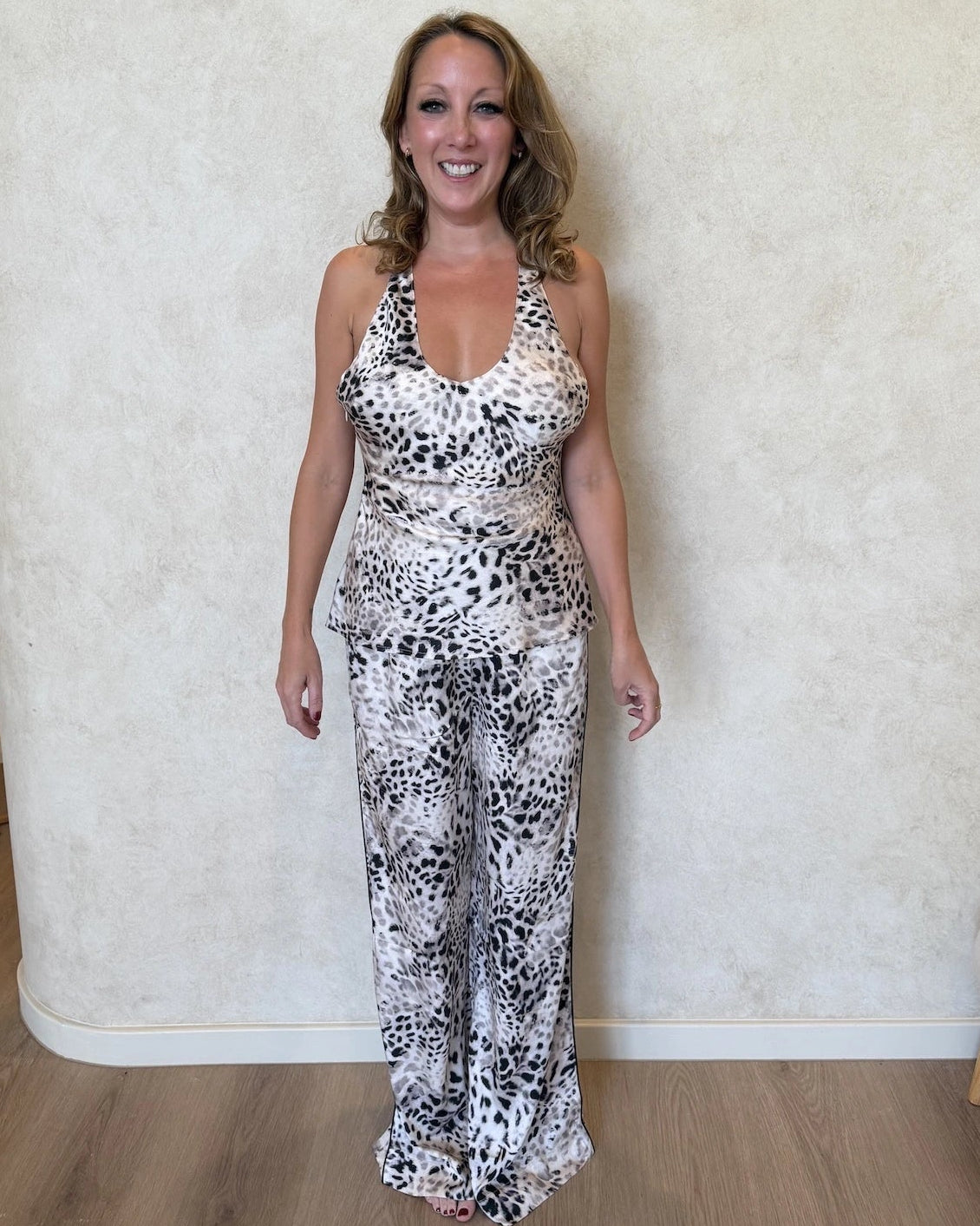 Woman wearing a leopard print cami top and matching pants.