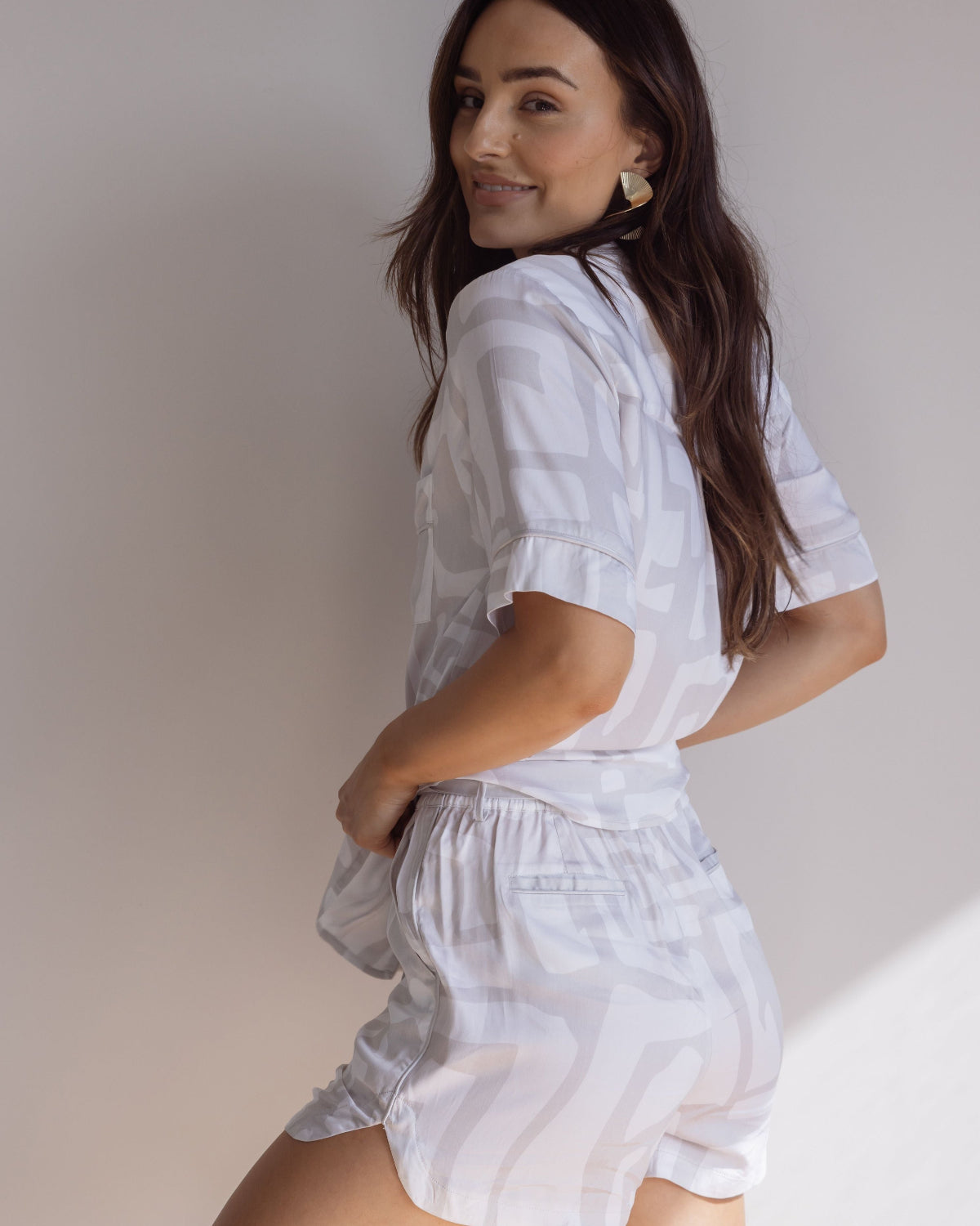 Woman wearing comfortable, breathable 100% bamboo PJ set showing a short sleeve pyjama top and a bold geometric print in light grey and white.
