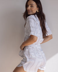 Woman wearing comfortable, breathable 100% bamboo PJ set showing a short sleeve pyjama top and a bold geometric print in light grey and white.
