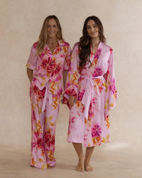 Two women in pink floral bamboo sleepwear. One in a kimono style robe, the other in a pyjama set with short sleeves and pants. These products are sold as a sleepwear bundle for extra savings.
