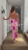 Woman wearing a pink floral slip dress with a low back and cross over spaghetti straps, she turns around to reveal a beautiful V neckline. Made from 100% bamboo satin.