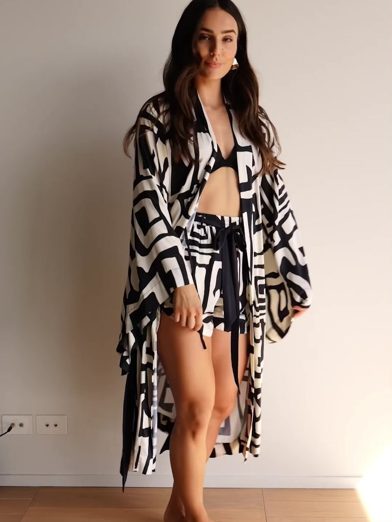 Video of a woman wearing a kimono-style robe, made from silky soft bamboo satin. Showing the details of the design including a hidden inside tie, waist tie and hidden pockes.