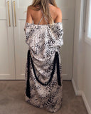 Back of a woman wearing a muted leopard print slip dress and matching kimono style robe, draped over her, showing a low back on the dress with cross over spaghetti straps. Silky soft bamboo satin.