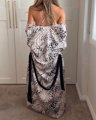 Back of a woman wearing a muted leopard print slip dress and matching kimono style robe, draped over her, showing a low back on the dress with cross over spaghetti straps. Silky soft bamboo satin.